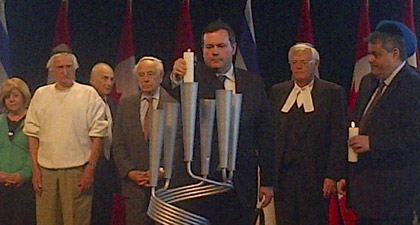 Minister Jason Kenney lights a candle at the National Holocaust Remembrance Day Ceremony.