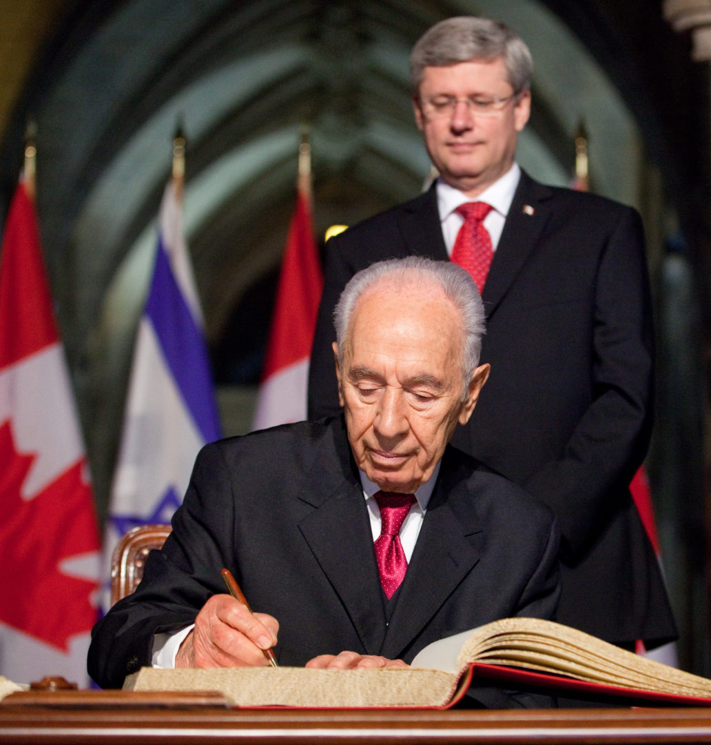 Shimon Peres signs the guest book in Ottawa