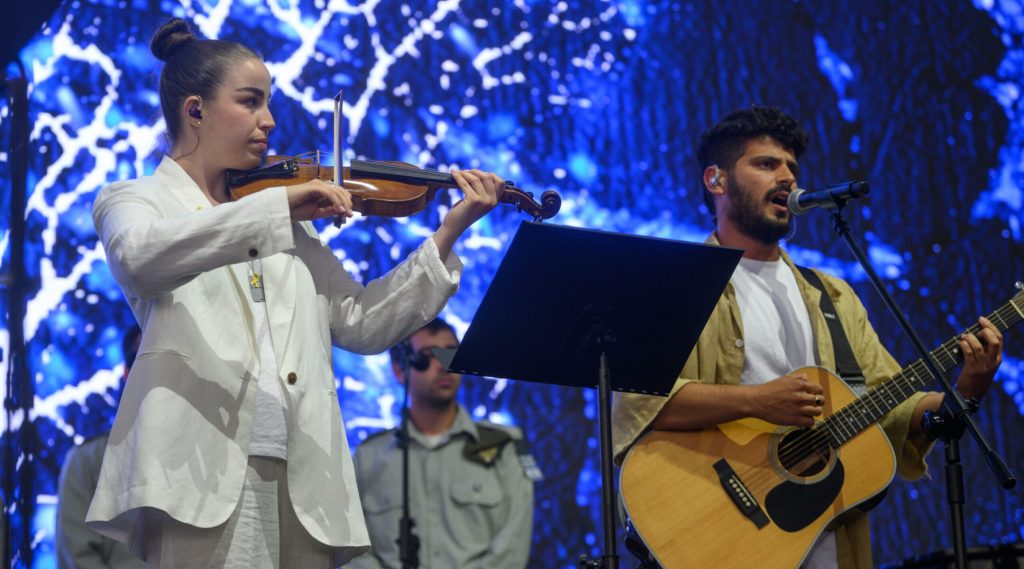 Released hostage Agam Berger, and Daniel Weiss, who survived Oct. 7 but lost his parents, perform during The International March Of The Living at Auschwitz- Birkenau on April 24, 2025, in Oswiecim, Poland. (Alexi Rosenfeld/Getty Images)